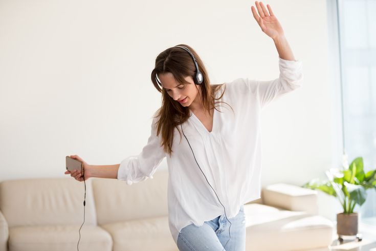 Carefree,Woman,In,Headphones,Dancing,To,Music,Playing,On,Smartphone